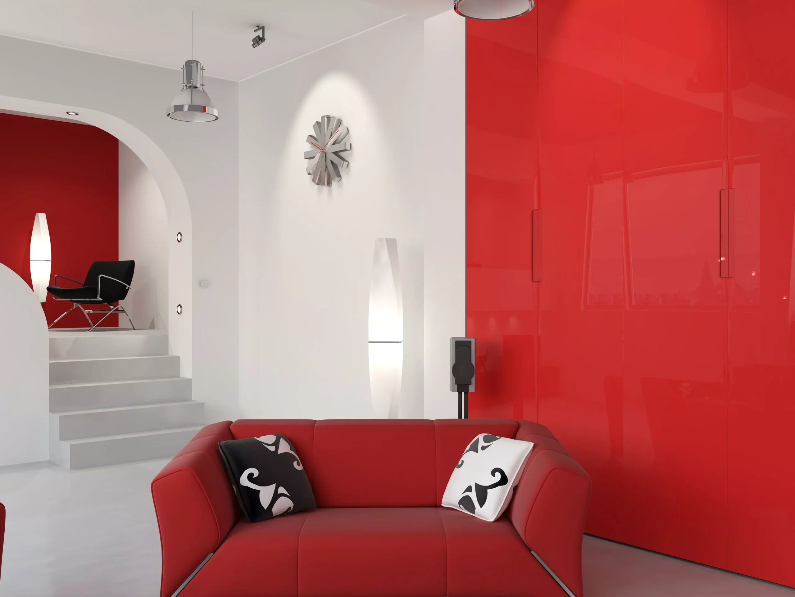 Sala de estar moderna con decoración en rojo y blanco, sofá rojo, cojines decorativos en negro y blanco, y gabinetes de cocina rojos brillantes en "cocinas Málaga" de "Akre cocinas".